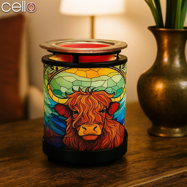 Cello Highland Cow Lamp glowing warmly on a wooden table, creating a cosy home atmosphere – perfect Highland cow light or unusual Highland cow gift.
