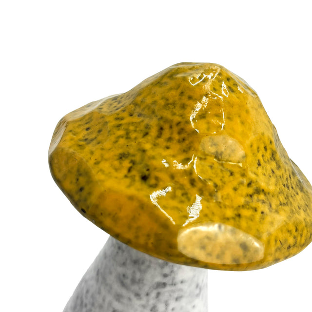Close-up of yellow porcelain decorative mushroom with earthy glaze and realistic handcrafted stem design
