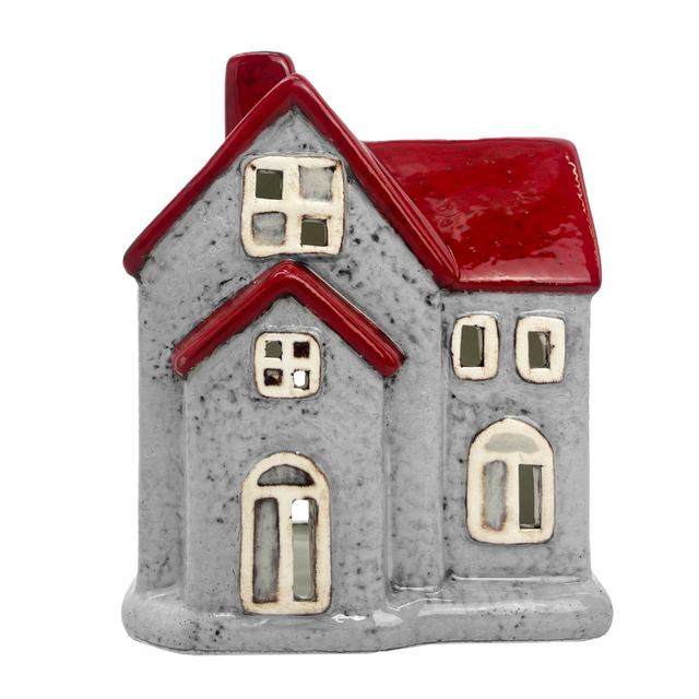 Ceramic house-shaped tealight holder with grey walls, red roof, and cut-out windows for light display. 