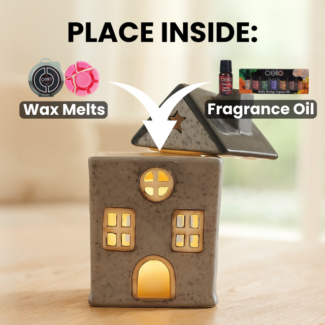 Star Cottage in grey and green ceramic house design shown on table with text highlighting compatibility with wax melts and essential oils or fragrance oils in wax melt burner.