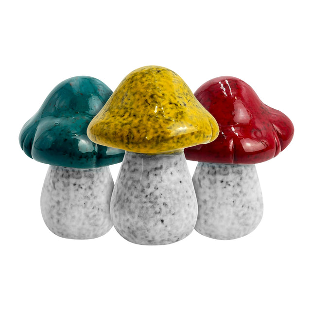 Set of three hand-crafted small porcelain decorative mushrooms with earthy glazes in green, red, and yellow, designed for modern and rustic home décor.