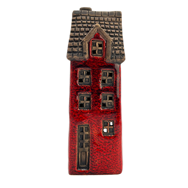 Front view of the Goldsmith’s Abode village pottery house with red ceramic finish and handcrafted window detailing.