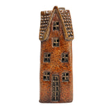 Front view of the Goldsmith’s Abode rustic brown village pottery house with tall windows, detailed brick texture, and warm ceramic finish.