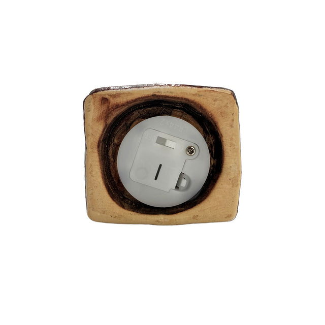 Close-up of the underside of the Goldsmith’s Abode LED pottery house showing the battery compartment and on/off switch for LED lighting.