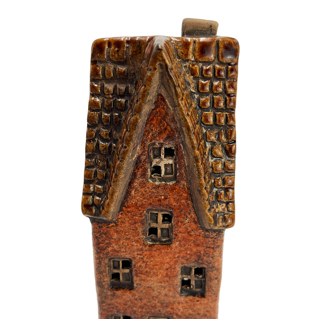 Close-up of the roof on the Goldsmith’s Abode ceramic house showing intricate hand-textured tiles and window craftsmanship.