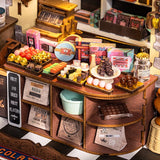 DG174 Henry's Chocolate ROBOTIME Rolife kits Miniature chocolate display with various chocolate items and packaging on a wooden stand.