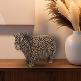 Resin Highland Cow ornament displayed on a sideboard with rustic décor, adding warmth and countryside charm to the living room.