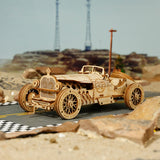 Wooden ROBOTIME ROKR Models Grand Prix Car vintage car on a desert road with mountains in the background