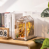 Decorative book nook model in ROBOTIME Rolife Book Nook Dust Cover WD1001 on a wooden surface with books.