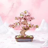 ROBOTIME Rolife Kits Sakura Bonsai against a pink background with white mountains.