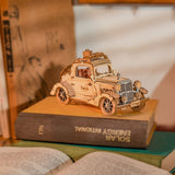 Wooden ROBOTIME Rolife Kits Vintage Car on top of a book with a blurred background