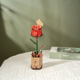 ROBOTIME Rowood Red Rose Wooden Flowers in a decorative pot on a textured surface.