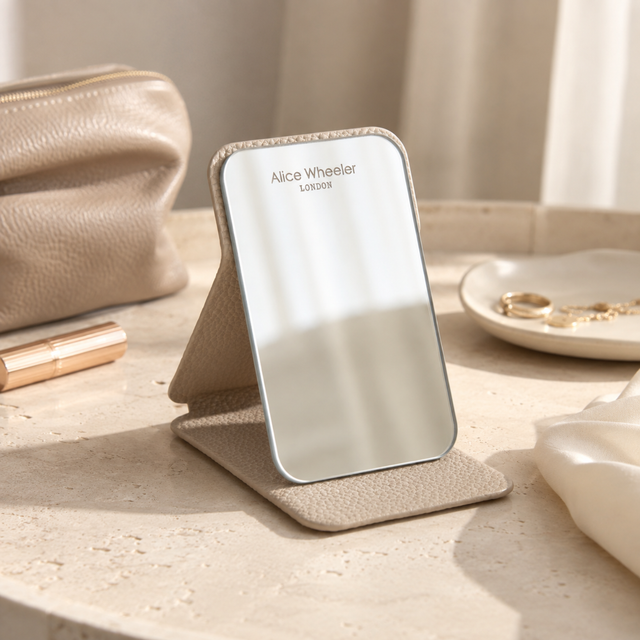 Alice Wheeler folding travel mirror in Stone with tabletop stand