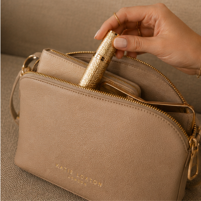 Alice Wheeler Gold refillable perfume atomiser styled with handbag and beauty accessories