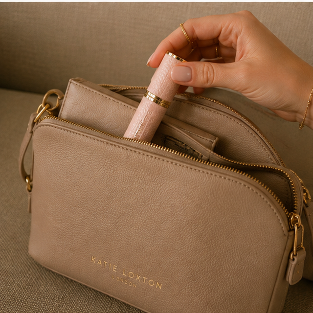 Alice Wheeler Pink travel perfume atomiser styled with handbag and beauty accessories