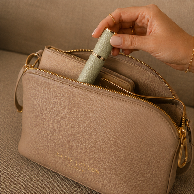 Alice Wheeler Pistachio travel perfume atomiser styled with handbag and beauty accessories