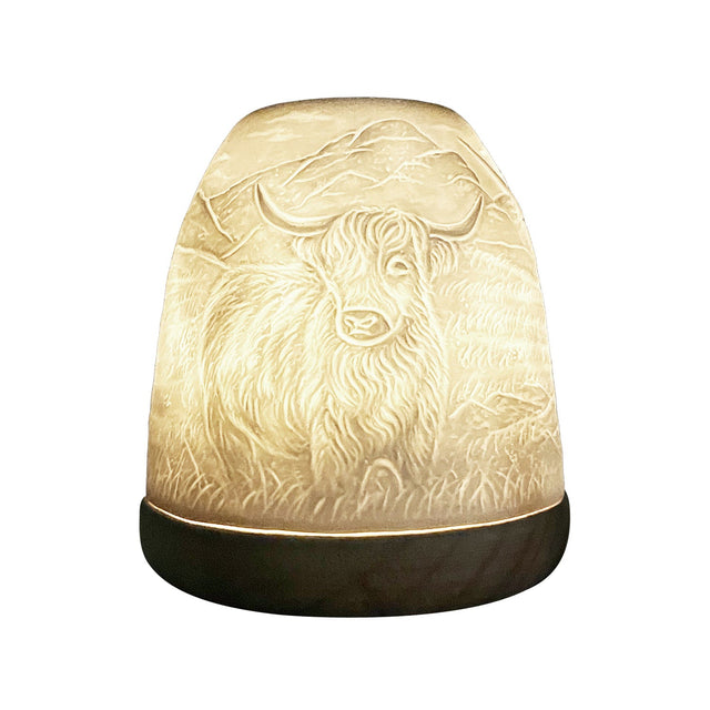 Close-up side view of glowing Highland Cow lithophane tealight candle dome