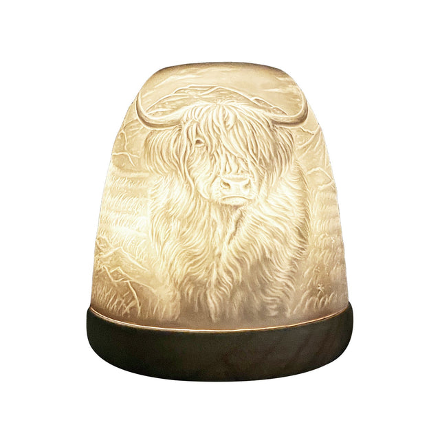 Cello Highland Cow tall porcelain tealight dome shown glowing from side angle