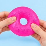Pink donut squishy toy being gently squeezed to show its texture