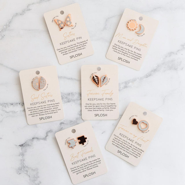 Flatlay of Splosh Forever Connected Keepsake Pin collection including Best Friends design