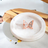 Sisters keepsake butterfly pin displayed on white ceramic dish