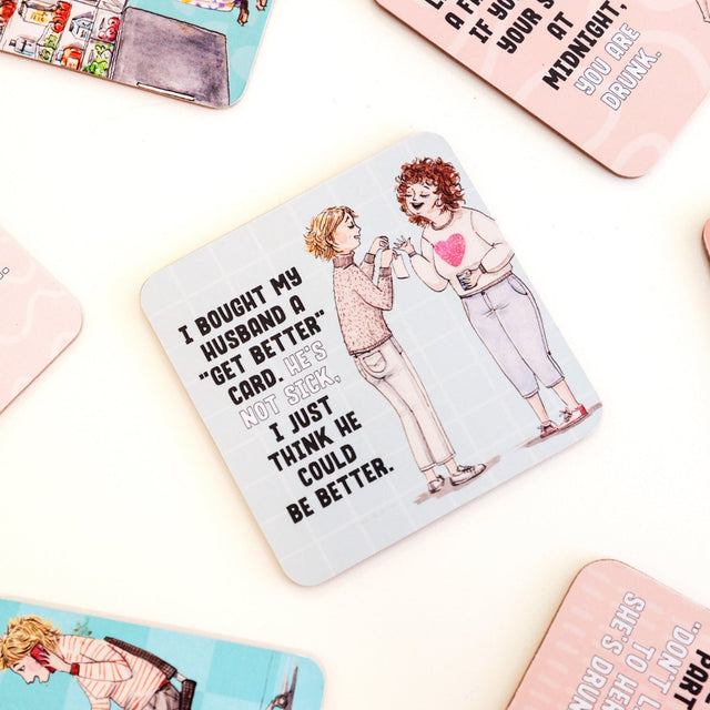 Drinks coasters with illustration of two people and humorous text on a light background