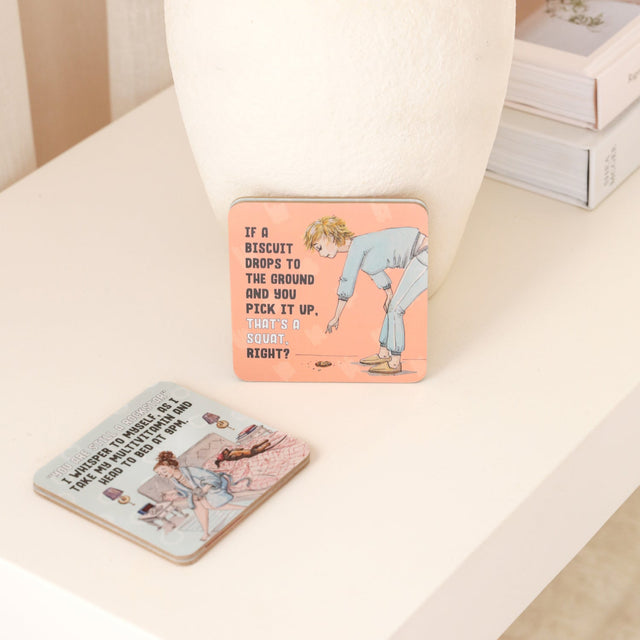 Drinks coasters with humorous designs on a light surface