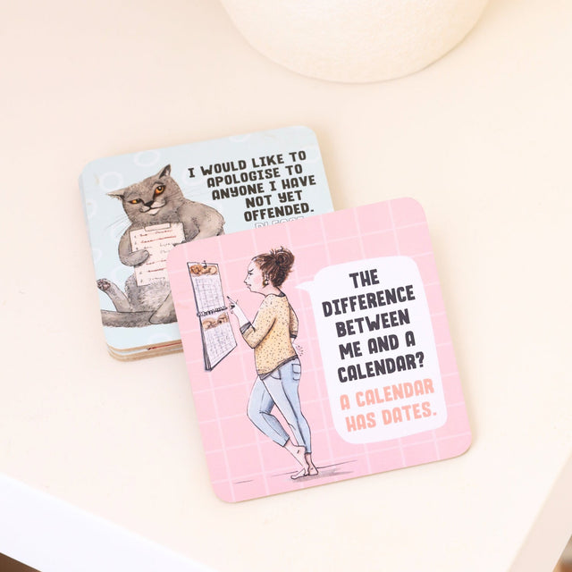 Two humorous drinks coasters with illustrations and text on a light background
