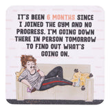 drinks coasters with cartoon illustration of a person sitting on a couch and text about gym progress.