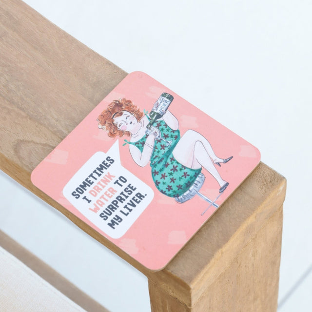 Drinks coasters with a humorous illustration of a woman and text on a wooden block