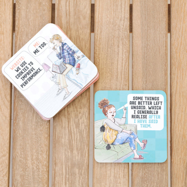 Illustrated drinks coasters on a wooden surface with humorous text and graphics.