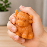 Highland cow squishy fidget toy being squeezed in hand for stress relief, anxiety reduction and sensory play