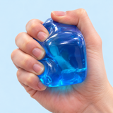Blue ice cube squishy toy being squeezed by hand