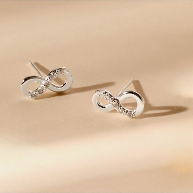 Silver infinity earrings jewellery flat lay