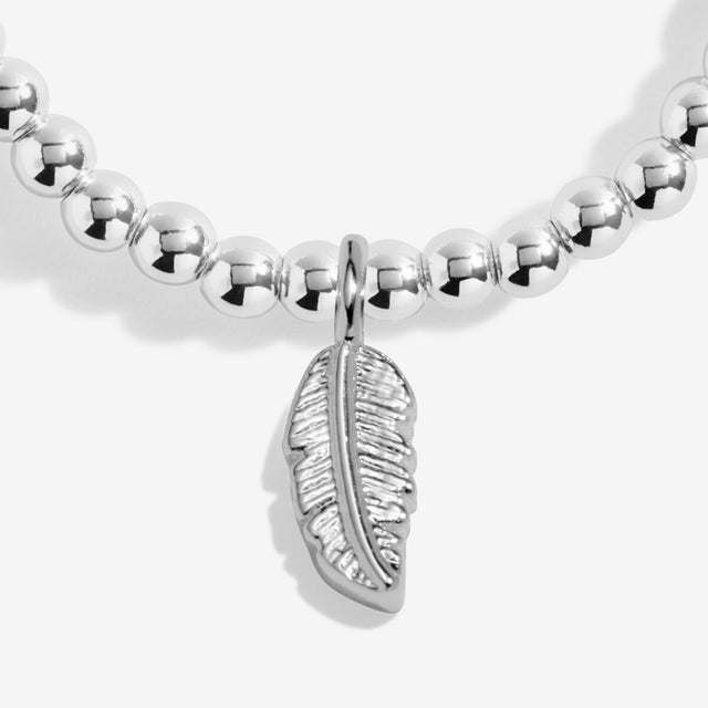 Feather charm detail on silver charm bracelet