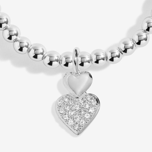 Close-up of heart charm on Joma Best Big Sis silver bracelet