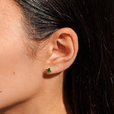 Woman wearing green and gold clover earrings