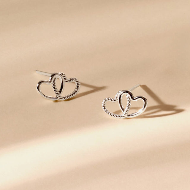 Silver heart friendship jewellery earrings styled on neutral background