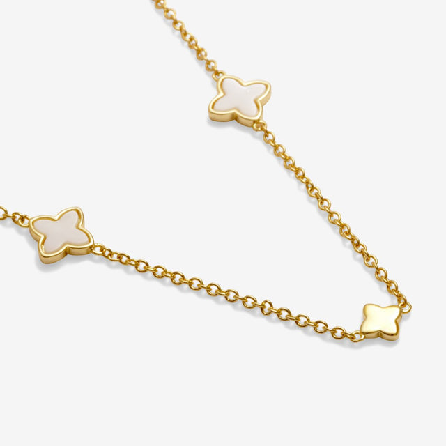 Close-up of gold clover charm on necklace