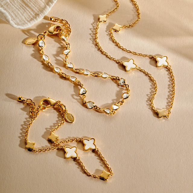 Gold clover necklace styled with matching bracelet and jewellery pieces