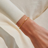 Gold pearl bracelet worn on wrist