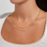 Double layered gold pearl necklace worn on collarbone