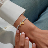 Silver beaded gold clover bracelet worn on wrist