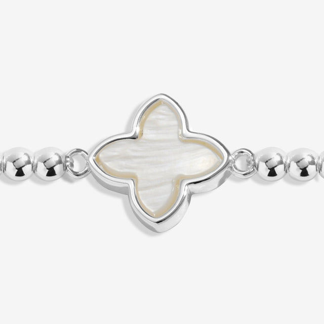 Close-up of silver-plated clover charm on Joma Happy Birthday bracelet