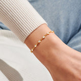 Gold heart tennis bracelet by Joma Jewellery worn on wrist
