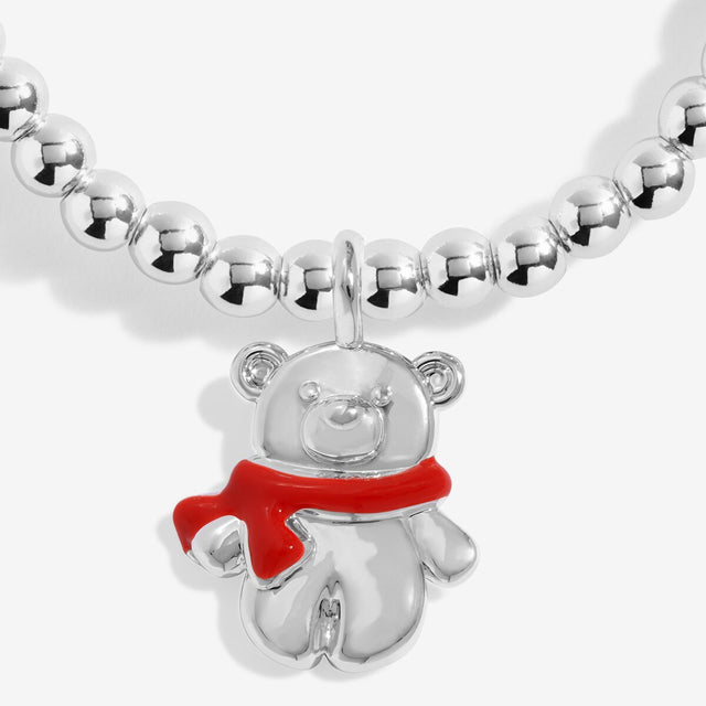Close-up of the teddy bear charm with a red scarf on Joma Jewellery's Christmas Cuddles kids' bracelet