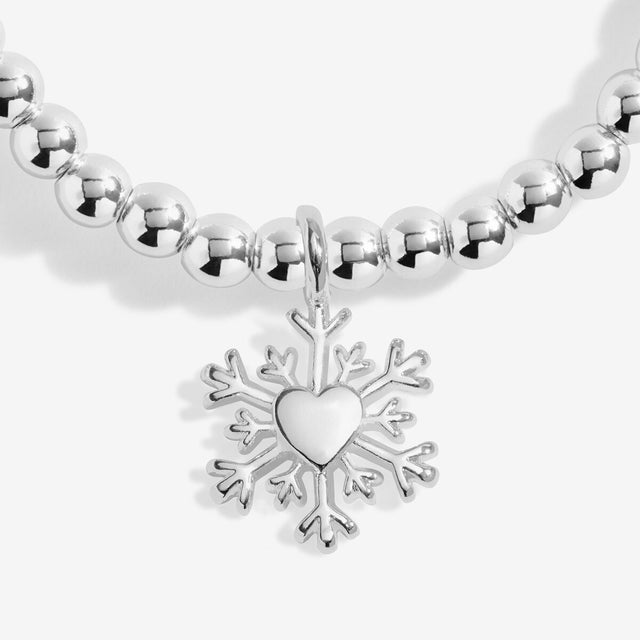 Close-up of the snowflake charm with a heart centre on Joma Jewellery's Christmas Wishes kids' bracelet