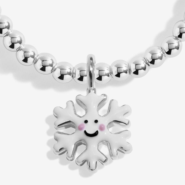 Close-up of the smiling snowflake character charm on Joma Jewellery's Jomees Let It Snow kids' bracelet