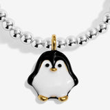 Close-up of the black and white penguin character charm with gold-coloured details on Joma Jewellery's Jomees Snow Cute kids' bracelet