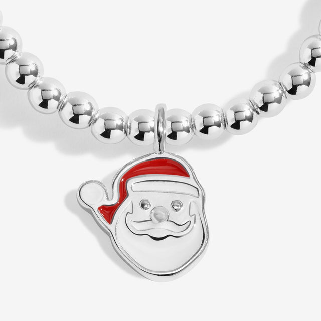 Close-up of the Santa face charm with a red hat on Joma Jewellery's Love From Santa kids' bracelet